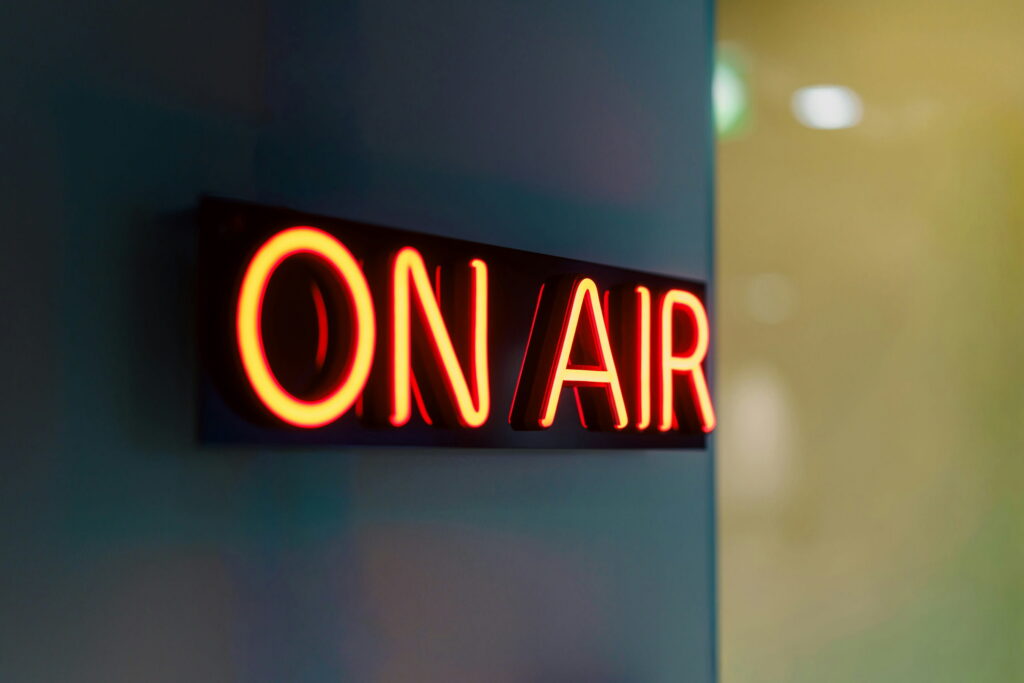 Colored lights on a wall read ON AIR to denote a livestream happening